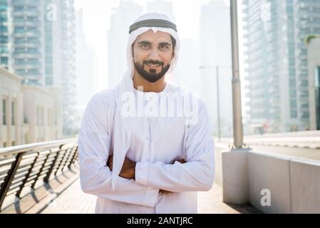 Mitte - östliche junge Erwachsene tragen kandora Walking im Freien in Dubai - Arabische Emirate Mann die traditionelle Kleidung Stockfoto
