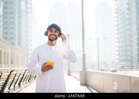 Mitte - östliche junge Erwachsene tragen kandora Walking im Freien in Dubai - Arabische Emirate Mann die traditionelle Kleidung Stockfoto
