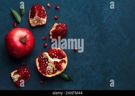 Saftige Granatapfel auf blauem Hintergrund mit Platz für Text. Blick von oben. Stockfoto