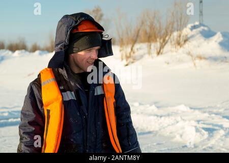 Arbeiter in einem orangefarbenen Helm mit einer Kapuze auf seinem Kopf Stockfoto