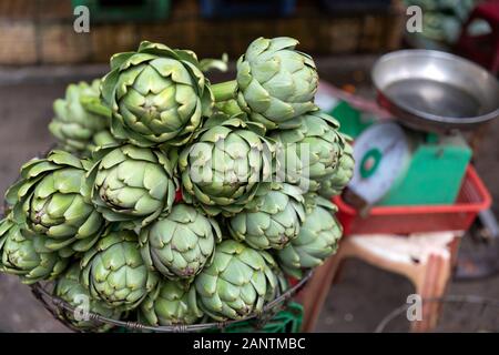 Artischocken werden in einem Markt mit Skalen im Hintergrund nicht scharf angezeigt Stockfoto