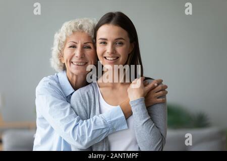 Kopf geschossen Portrait happy fürsorgliche Großmutter, umarmen, Enkelin Stockfoto