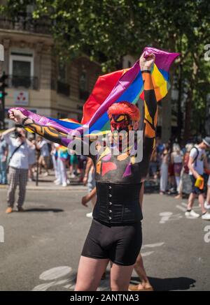 29. Juni 2019, Paris, Frankreich. Gay Pride Parade Tag. Junge Mann hält eine Fahne. Sein Gesicht und Körper sind lackiert! Schönes Design & Motive. Stockfoto