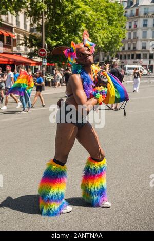 Juni 2019, Paris, Frankreich. Tag Der Parade Der Homosexuellen Stolz. Entkleidet lächelnd schwarz extravaganter junger Mann mit Regenbogenstiefeln. Kamera-Look. Stockfoto