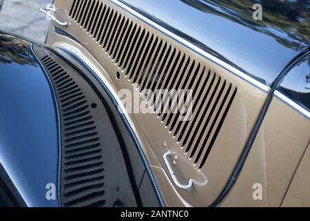 Bonnet- oder Kapuzendetail Vintage French Car in zwei Farben schwarz und Gold mit schöner Spiegelung und selektivem Fokus Stockfoto