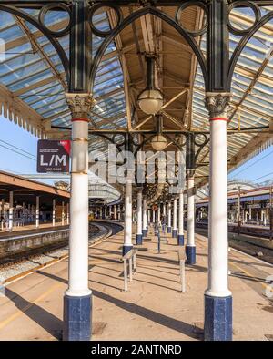 Eine reich verzierte 19. Jahrhundert Plattform Vordach an der York Railway Station. Dekorative Säulen halten ein Vordach aus Metall und Lampen hängen an den Sparren. Stockfoto