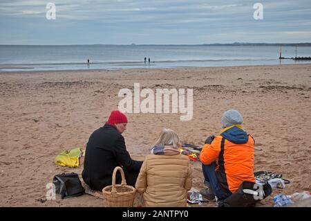 Portobello Beach, Edinburgh, Schottland, Großbritannien. Januar 2020. Während die Studenten der Universität Edinburgh dachten, dass 6 Grad Celsius für ein schnelles Baden in Der Forth in Ordnung waren, beschlossen andere ein Picknick rund um ein Feuer am Strand sinnvoller. Stockfoto