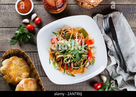 Traditionelle asiatische usbekischen Nudel lagman mit Gemüse und Fleisch auf rustikalen Holztisch Hintergrund. Ansicht von oben Stockfoto
