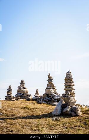 Vielen Man-made Granit Stapel (Cairns) auf dem Küstenweg in der Bretagne, Frankreich, an einem sonnigen Nachmittag. Stockfoto