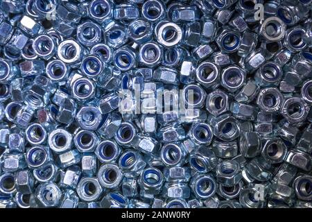 Ein Stapel aus verzinktem industriellen Nüsse. Metallmutter Textur, industriellen Hintergrund. Stockfoto