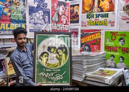 Kaleem Khan, ein Miteigentümer von Shop Poster Stuff in Chor Bazar (Diebemarkt), Mumbai, Indien, hält ein Originalposter des Films Pather Panchali Stockfoto