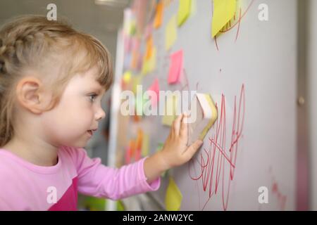 Kleines Mädchen löscht Schriftzug Stockfoto