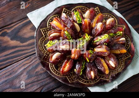 Getrocknete Datteln gefüllt mit kandierten Früchten und Nüssen auf einem rustikalen Holztisch mit kopieren. Stockfoto