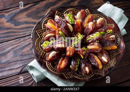 Getrocknete Datteln gefüllt mit kandierten Früchten und Nüssen auf einem rustikalen Holztisch mit kopieren. Stockfoto