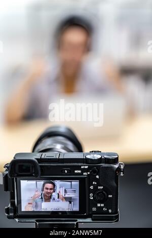 Jungen asiatischen männlichen Gamer Casting und der Rundfunk seine online spielen Video Game mit digitalen Kamera Recording Live vlog Video. Online influcencer ein Stockfoto