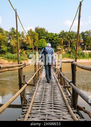 Älterer Mann touristische gehen auf wackeligen bamboo Brücke, Fluss Nam Khan, Luang Prabang, Laos Stockfoto