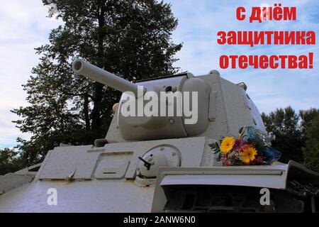 23. Februar Grußkarte. Militärische Tank, Blume auf natürliche Hintergrund. Gerne Verteidiger des Vaterlandes Tag in Russischer Sprache. Stockfoto