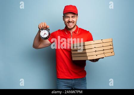 Der Lieferer ist pünktlich, um schnell Pizzen zu liefern. Hintergrund Zyan Stockfoto