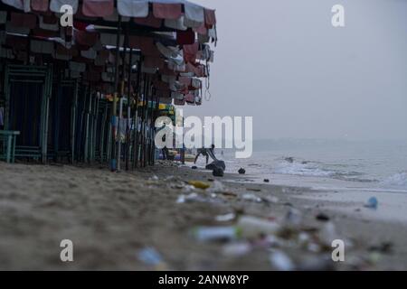Saen Suk, Chonburi, Thailand. 19 Jan, 2020. Ein Mann nimmt einen Sack mit Müll vom Ufer auf Bang Saen Beach am Golf von Thailand gesammelt. Thailand, die sich mit dem Problem der Umweltauswirkungen von Abfall bis Waschen an den Stränden wurde und sich negativ auf die Tierwelt in den letzten Jahren und am 1. Januar 2020 erließ ein Verbot mit Plastiktüten. Credit: Adryel Talamantes/ZUMA Draht/Alamy leben Nachrichten Stockfoto