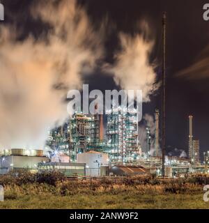 Nachtaufnahme mit Blick auf petrochemische Produktionsanlage mit Federn von Rauch, der Hafen von Antwerpen, Belgien. Stockfoto