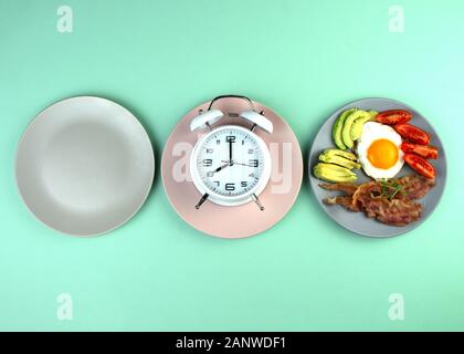 Intermittierendes fasten Konzept mit leeren bunte Platten. Zeit Gewicht zu verlieren, Kontrolle oder Zeit Essen Diät Konzept. Stockfoto