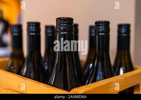 Weine Flasche Dark Amber Glas, Lack und Hals, selektiven Fokus auf Flaschen auf hölzernen Flasche Wein Kiste, mit schwarzem Schraubverschluss Stockfoto