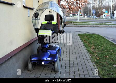 Blaue vier Rädern Mobility Scooter-elektrischen Rollstuhl außerhalb eines Hauses geparkt. Stockfoto