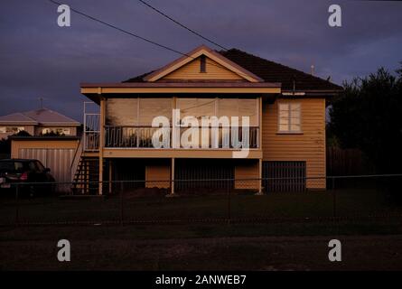 Ein Vorstadthaus in Carina Brisbane, 70er Jahre 80er Jahre umschlossene Veranda, fotografiert bei Sonnenuntergang, Licht reflektiert in der „neuen“ Glaswand Stockfoto