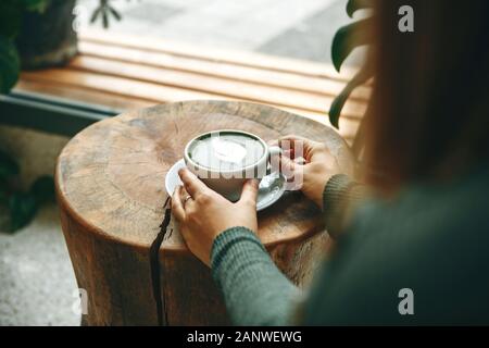 Mädchen Getränke aromatische Frische und gesunde Green Matcha Latte Kaffee in einem Café. Stockfoto