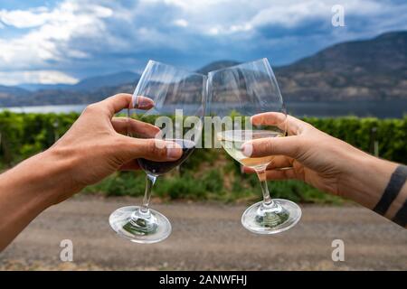 Outdoor Wein trinken und Verkostung, Weingut Bauernhäuser und Weinberge, Mann und Frau paar Reise nach Okanagan Lake Okanagan Valley, BC, Kanada Stockfoto