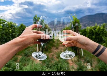 Hände, die Weine Gläser und jubeln, outdoor Wein trinken und Verkostung, Kanadische Winery Tour besuchen, Weinberge in Okanagan Lake Hintergrund Stockfoto