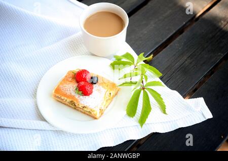 Große Kaffeebecher. Heiße Schokolade und Käsekuchen auf dem Tisch. Cappuccino Kaffee und süßes Karamell Kuchen. Eine Tasse Latte, Cappuccino oder Espresso Stockfoto