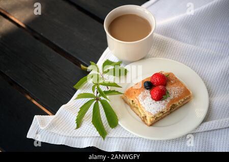 Große Kaffeebecher. Heiße Schokolade und Käsekuchen auf dem Tisch. Cappuccino Kaffee und süßes Karamell Kuchen. Eine Tasse Latte, Cappuccino oder Espresso Stockfoto