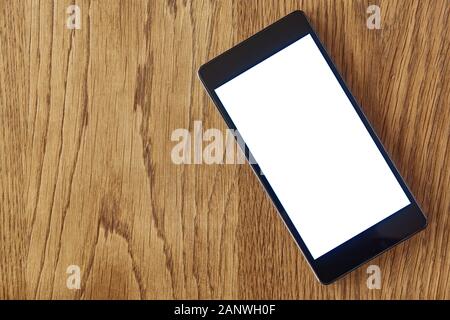 Smartphone mit leerem weißen Bildschirm auf Holztisch. Flach legen Handy-Bildschirm Vorlage und Modell mit Kopierplatz Stockfoto