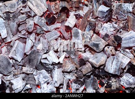 Kohle brennen. Glühende Glut. Feuerstelle mit glühender Kohle. Live-Kohleverbrennung. Hintergrund. Nahaufnahme. Stockfoto