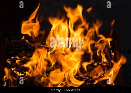 Feuer und Flammen. Brennendes Brennholz im Kamin. Brennendes Brandholz und Nahaufnahme. Feuer und Flamme mit brennendem Hintergrund. Stockfoto