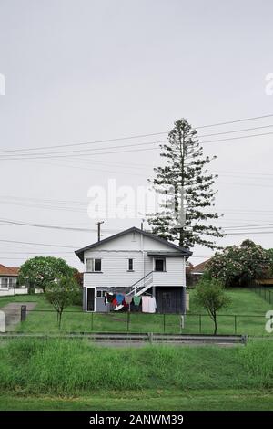 A Post war, Housing Commission House auf einem großen grasbewachsenen Block mit einer Einfahrt aus Betonplatten im Brisbane Vorort Seven Hills Stockfoto