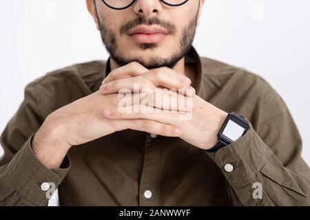Den unteren Teil des Gesichts- und gekreuzten Fingern der jungen ruhig bärtiger Mann im Hemd Stockfoto