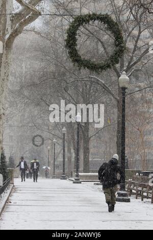 Philadelphia, PA, USA - 18. Januar 2020: Bewohner Spaziergang durch Rittenhouse Square Park während der ersten Schneesturm, der Stadt des Jahres. Stockfoto