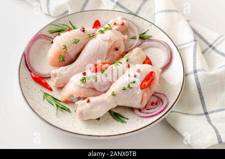 Weiße Schale mit würzig marinierte Hähnchenschenkel oder Unterschenkel. Rohes Fleisch und kochen Konzept. Stockfoto