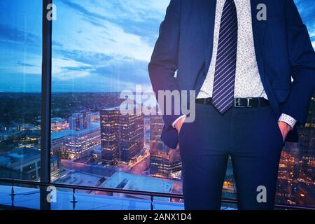 Geschäftsmann in Anzug und Krawatte stehen in der Nähe der Fenster von downtown Bellevue, Washington, USA Stockfoto