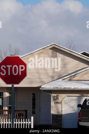 Stoppschild und schneebedecktes Dach. Stockfoto