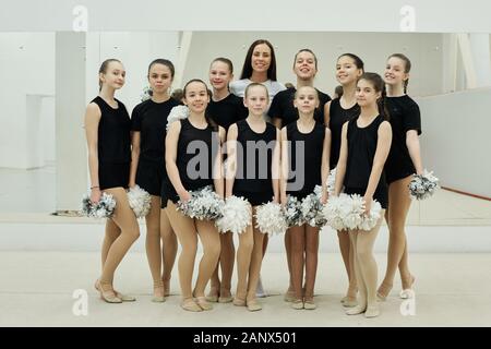 Junge Trainer mit Team cheerleading Mädchen Stockfoto