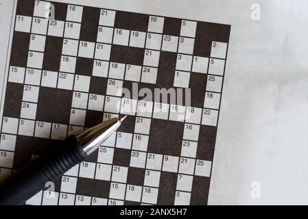 Kreuzworträtsel vom Zeitung mit einem Stift in Antworten zu füllen Stockfoto