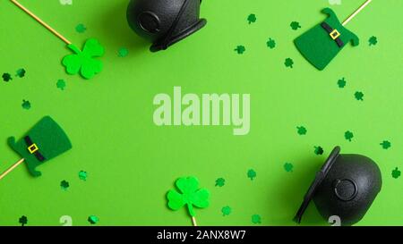 St Patricks Day Hintergrund mit Töpfe Gold, Kobold Hüte, shamrock Four Leaf Clover und Konfetti auf Grün. Saint Patrick's day Banner Design, pos Stockfoto