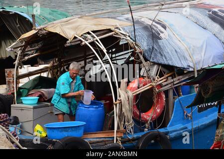 Ein alter Fischer arbeitet an seinem verfallenen Boot im sicheren Hafen des Shau Kei Wan Typhoon Shelter im Quarry Bay District in Hongkong. Stockfoto