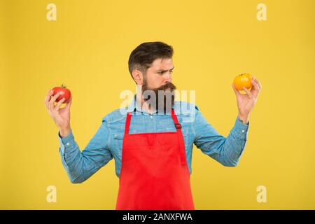 Tipps für das Wachstum am besten Tomate. Nutzen für die Gesundheit der Tomate. saftig und süß Gemüse. brutale Koch im Vorfeld. bärtiger Mann Chef mit Tomate. Tomaten sind ein äußerst nahrhafte pflanzliche Nahrung. Bio Diät. Stockfoto