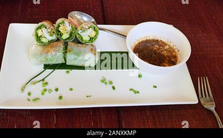 Gemüse Nudeln (Pho Cuon) auf die weiße Platte mit Soße auf dem roten Tisch gerollt, Vietnamesisch vegetarische und vegane Lebensmittel in Kambodscha Stockfoto