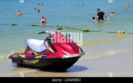 Ein Jetski und Leute genießen das Meer Wasser in einen sicheren Bereich, gekennzeichnet durch eine Floatanlage in Patong Beach, Phuket, Thailand, Asien, an einem heißen Tag Stockfoto