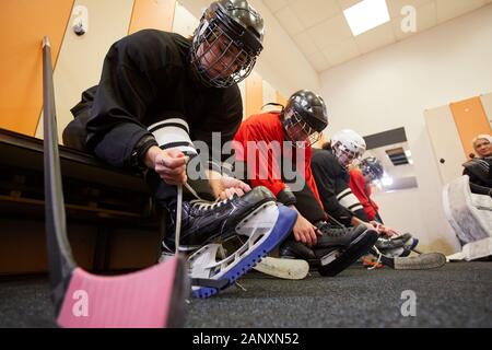 Low Angle View an weiblichen Hockey Team setzen auf Zahnrad in der Umkleide beim Vorbereiten für Match oder Praxis, kopieren Raum Stockfoto